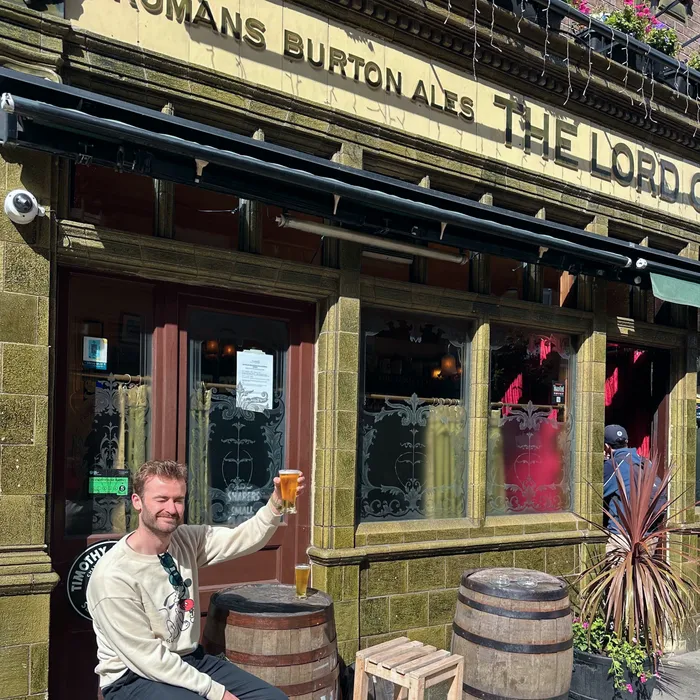 Jake raising a pint outside a London pub after the workshop